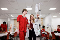 A nursing student speaking with a professor.